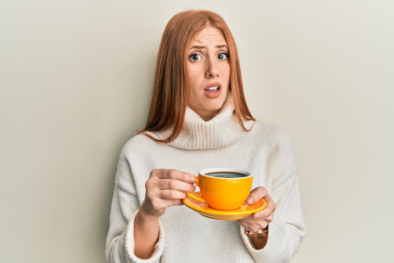 Junge irische Frau trinken eine Tasse Kaffee ratlos und verwirrt Ausdruck lizenzfreie stockfotos