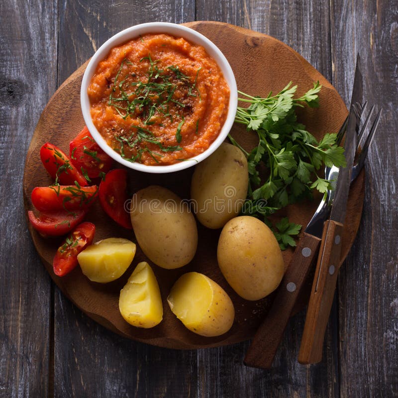 Junge Kartoffeln gekocht in einer Schale mit Zucchinikaviar, Gewürzen, ffresh Tomaten und Petersilie stockfoto Junge Kartoffeln gekocht in einer Schale mit Zucchinikaviar, Gewürzen, ffresh Tomaten und Petersilie stockfoto