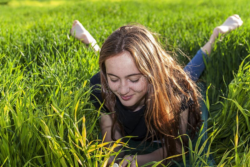 Junge kaukasische rothaarige Frau, wenn dem langen Haar und die Sommersprossen, auf dem Gras liegen lizenzfreies stockfoto Junge kaukasische rothaarige Frau, wenn dem langen Haar und die Sommersprossen, auf dem Gras liegen lizenzfreies stockfoto