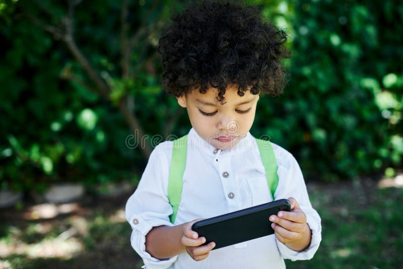 Junge Kind und Outdoor oder online mit Smartphone zum Streaming von Cartoons oder Filmen und Anwendung für Bildung stockfotos