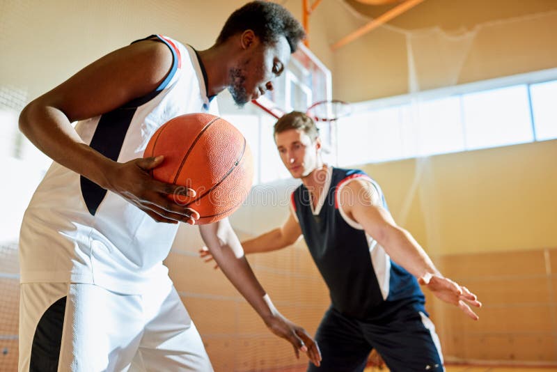 Junge Konkurrenten, die Basketball auf Trainingsgericht spielen lizenzfreies stockfoto Junge Konkurrenten, die Basketball auf Trainingsgericht spielen lizenzfreies stockfoto