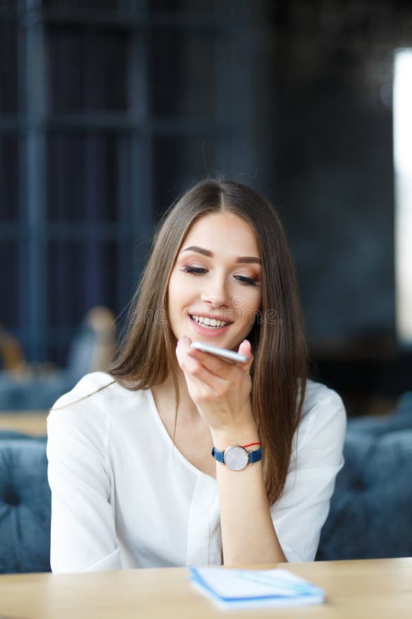 Junge lange Haardame, die telefonisch im Restaurant spricht lizenzfreie stockfotografie Junge lange Haardame, die telefonisch im Restaurant spricht lizenzfreie stockfotografie