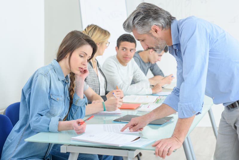 Junge Leute, die im Klassenzimmer schreiben stockbild Junge Leute, die im Klassenzimmer schreiben stockbild