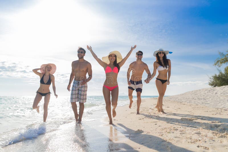 Junge Leute-Gruppe auf Strand-Sommer-Ferien, glückliche lächelnde Freund-gehende Küste lizenzfreie stockbilder Junge Leute-Gruppe auf Strand-Sommer-Ferien, glückliche lächelnde Freund-gehende Küste lizenzfreie stockbilder