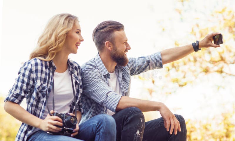 Junge liebevolle Paare, die selfie Foto im Herbstpark machen stockfotografie Junge liebevolle Paare, die selfie Foto im Herbstpark machen stockfotografie