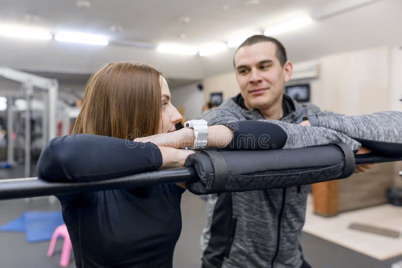 Junge l?chelnde Eignungspaare, die in der Turnhalle sprechen Sport, Training, Familie und gesunder Lebensstil stockbild Junge l?chelnde Eignungspaare, die in der Turnhalle sprechen Sport, Training, Familie und gesunder Lebensstil stockbild