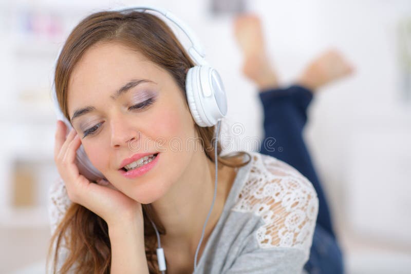 Junge lächelnde Frau entspannen und Musik mit Kopfhörern hören stockbild