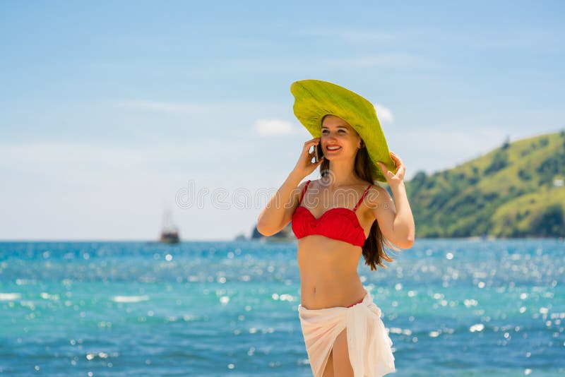 Junge lächelnde Schönheit bei der Unterhaltung am Handy auf dem Strand lizenzfreies stockbild Junge lächelnde Schönheit bei der Unterhaltung am Handy auf dem Strand lizenzfreies stockbild