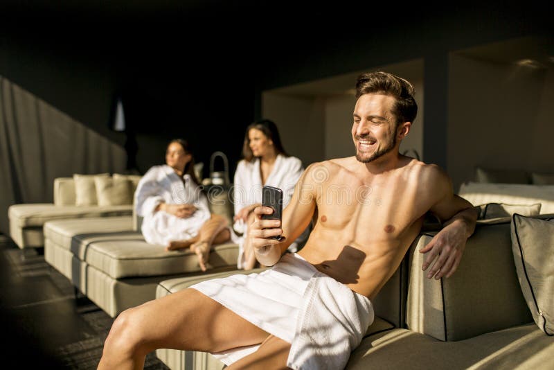 Junge Mann im Zimmer mit Mobiltelefon lizenzfreie stockfotos Junge Mann im Zimmer mit Mobiltelefon lizenzfreie stockfotos