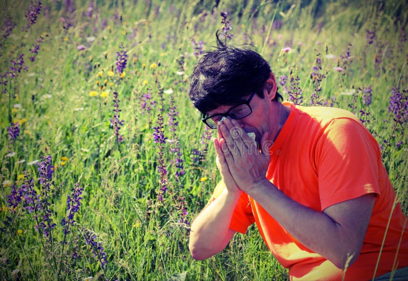 Junge mit orange Hemdniesen weil Allergie stockbild Junge mit orange Hemdniesen weil Allergie stockbild