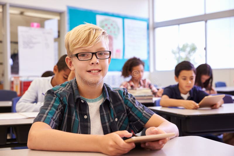 Junge mit Tablette in der grundlegenden Schulklasse, Porträt stockfotos Junge mit Tablette in der grundlegenden Schulklasse, Porträt stockfotos