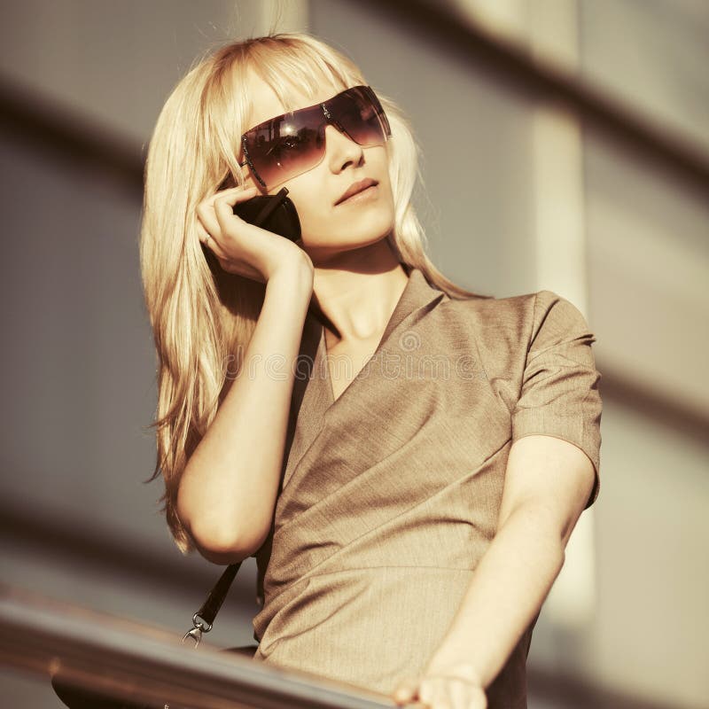 Junge ModeGesch?ftsfrau in der Sonnenbrille um Handy ersuchend stockfoto Junge ModeGesch?ftsfrau in der Sonnenbrille um Handy ersuchend stockfoto