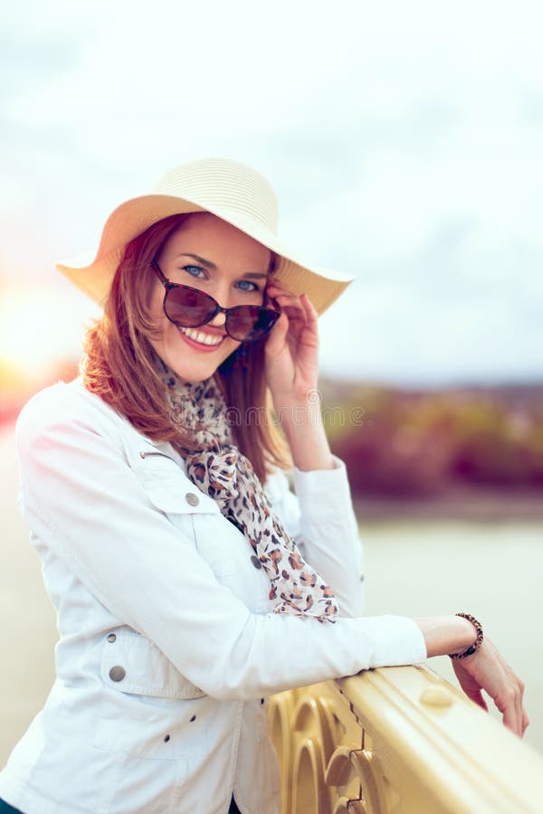 Junge moderne st?dtische Frau im Hut entfernen Sonnenbrille stockbilder Junge moderne st?dtische Frau im Hut entfernen Sonnenbrille stockbilder