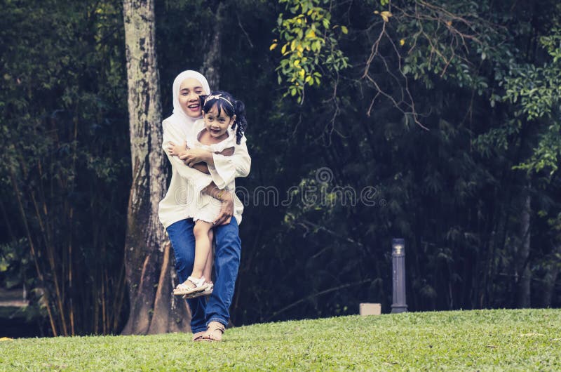 Junge Mutter des glücklichen Ausdrucks mit ihrer Tochter genießen, Spaß am allgemeinen Park habend stockfotos Junge Mutter des glücklichen Ausdrucks mit ihrer Tochter genießen, Spaß am allgemeinen Park habend stockfotos