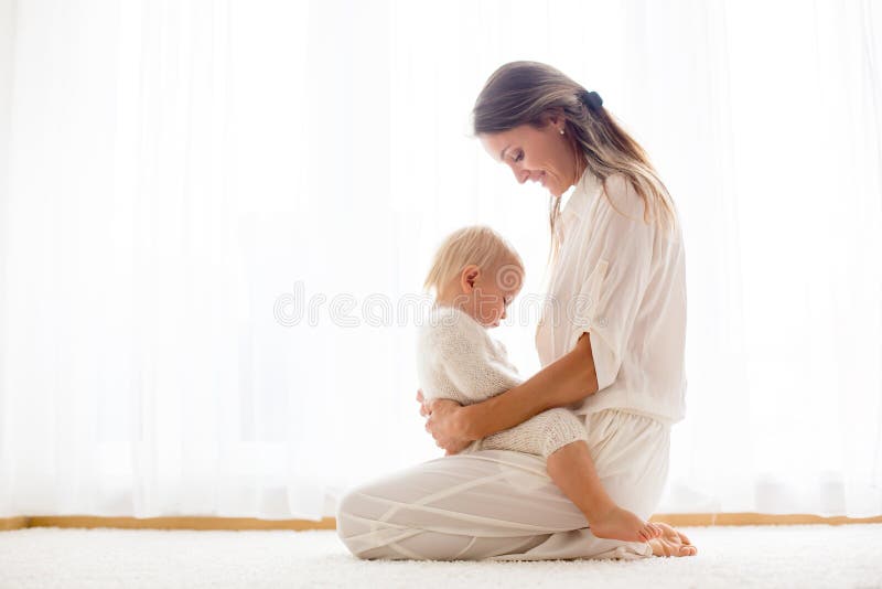 Junge Mutter, die ihr Kleinkindbaby stillt lizenzfreies stockbild Junge Mutter, die ihr Kleinkindbaby stillt lizenzfreies stockbild