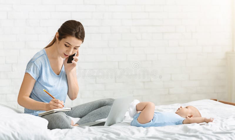 Junge Mutter, die telefonisch telefonisch spricht und ein Vorstellungsgespräch arrangiert lizenzfreies stockfoto