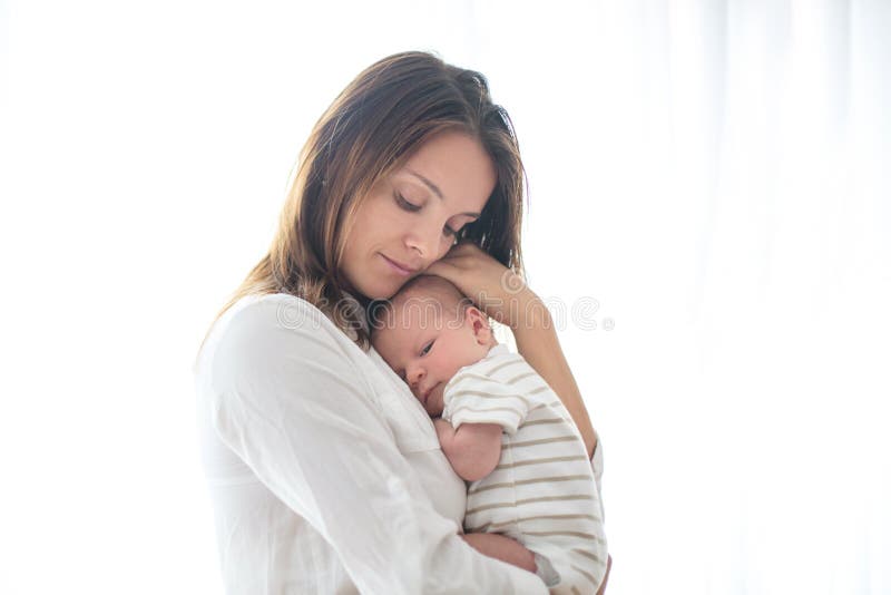 Junge Mutter, ihr neugeborenes Baby halten stockbild Junge Mutter, ihr neugeborenes Baby halten stockbild