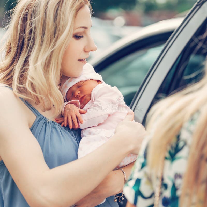 Junge Mutter mit ihren Neugeborenen Babystellung nahe dem Auto lizenzfreie stockfotos