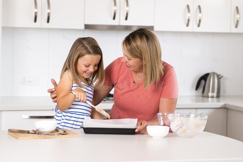 Junge Mutter und süße kleine Tochter, die zusammen zu Hause glückliche Küche im Familienlebensstilkonzept backt lizenzfreie stockfotografie Junge Mutter und süße kleine Tochter, die zusammen zu Hause glückliche Küche im Familienlebensstilkonzept backt lizenzfreie stockfotografie