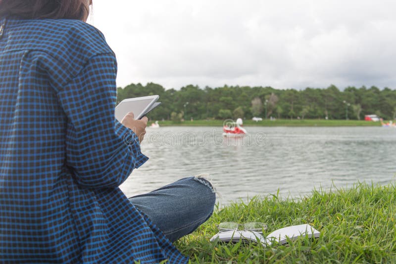 Junge Mädchen mit Tablet im Park lizenzfreies stockbild Junge Mädchen mit Tablet im Park lizenzfreies stockbild