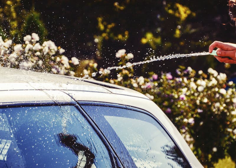 Junge Männer, Die Silbernes Auto Mit Druckwasser Und Bürste Am Sonnigen