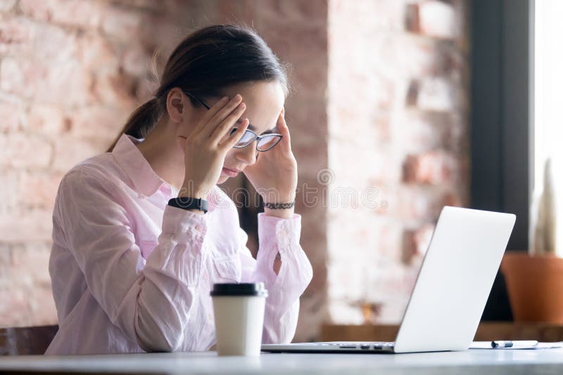 Junge müde Frau in den Brillen, die im Computer arbeiten lizenzfreie stockbilder Junge müde Frau in den Brillen, die im Computer arbeiten lizenzfreie stockbilder