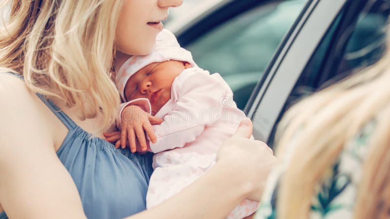 Junge Mütter mit ihren Neugeborenen Babystellung nahe dem Auto. stockbilder