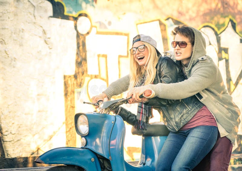 Junge Paare in der Liebe, die Spaß auf einem Weinleserollermoped hat lizenzfreie stockfotografie Junge Paare in der Liebe, die Spaß auf einem Weinleserollermoped hat lizenzfreie stockfotografie