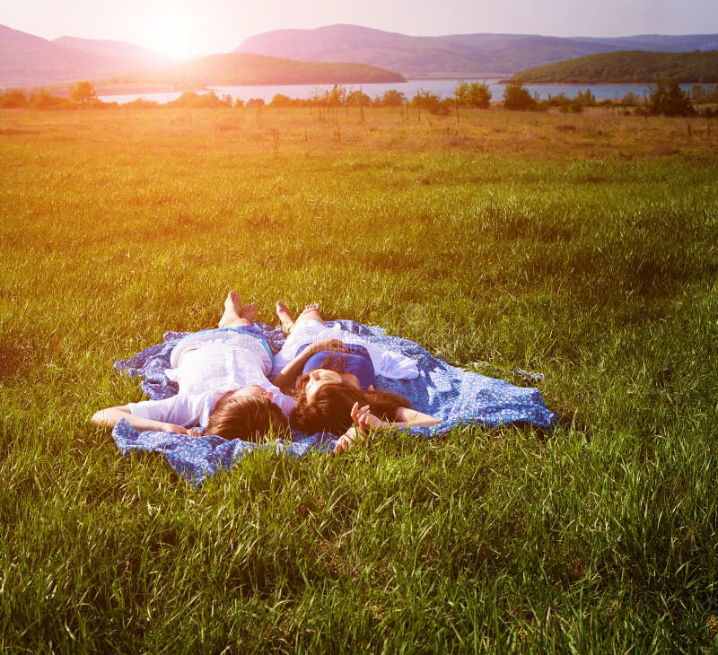 Junge Paare, Die Auf Dem Gras Liegen Stockbild - Bild von lebensstil