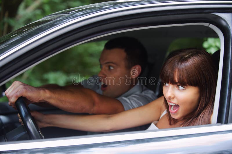 Junge Paare, die Auto antreiben lizenzfreie stockbilder Junge Paare, die Auto antreiben lizenzfreie stockbilder
