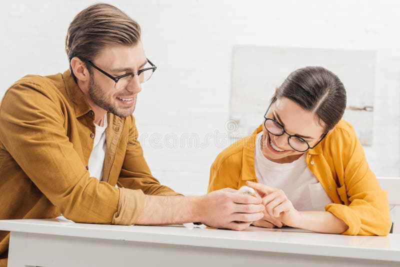 Junge Paare, die um wenigem Küken auf Tabelle sich kümmern stockbild