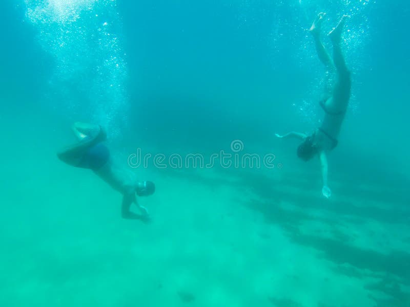 Junge Paarschwimmen in einem transparenten Ozeanwasser in Spanien stockbilder Junge Paarschwimmen in einem transparenten Ozeanwasser in Spanien stockbilder