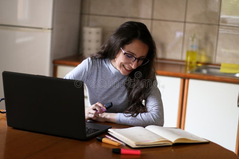 Junge Professorin bereitet sich auf ihren Online-Unterricht zu Hause vor. Junge Mathematikprofessorin bereitet sich auf ihre Online-Unterrichtsstunde zu Hause in ihrer Wohnung vor