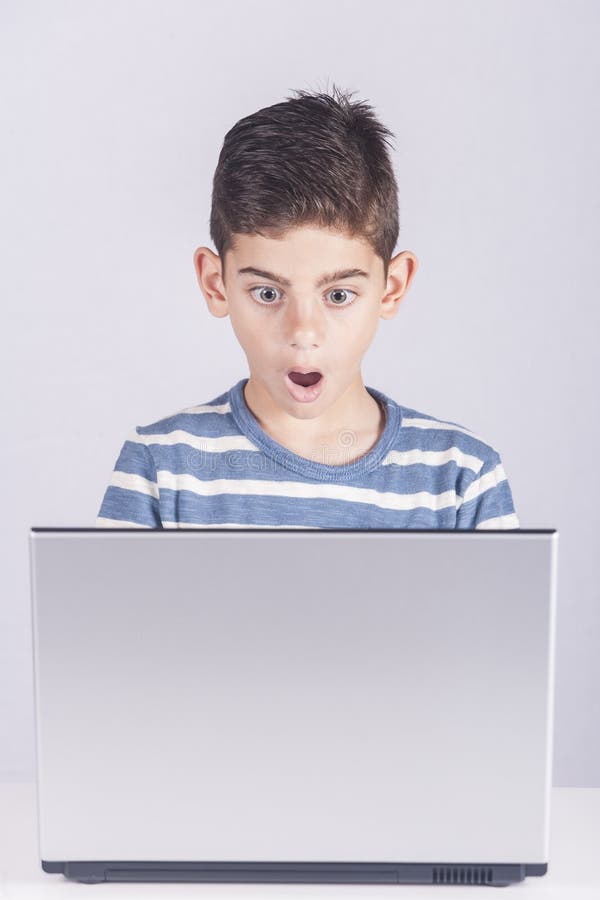 Junge reagiert bei der Anwendung eines Laptops lizenzfreie stockbilder Junge reagiert bei der Anwendung eines Laptops lizenzfreie stockbilder