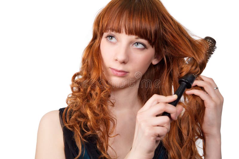 Junge Redheadfrau, die ihr Haar geraderichtet