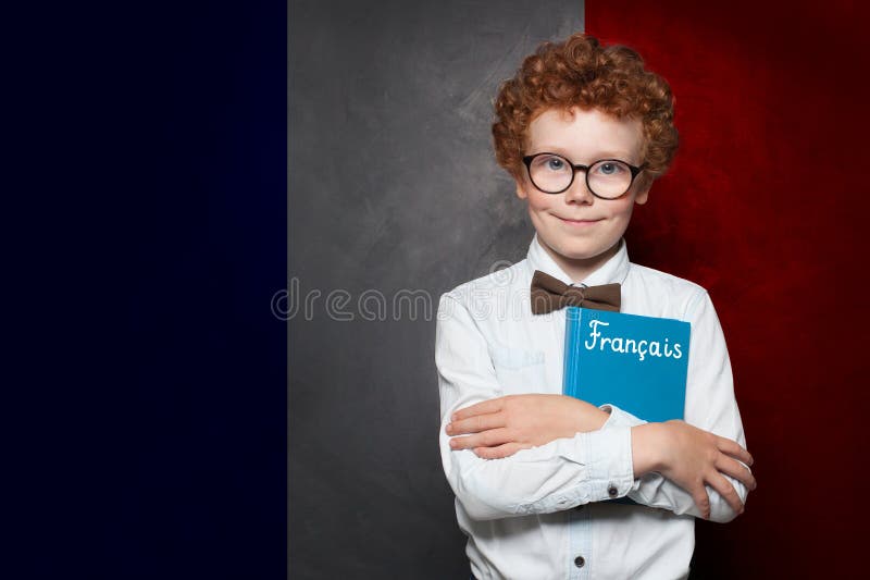Junge Schuljunge mit der Aufschrift Francais in Frankreich vor französischem Hintergrund. stockbilder