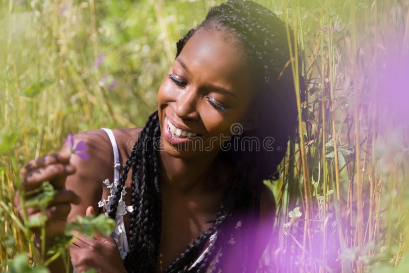 Beautiful young black woman enjoying nature in a high grass meadow. Beautiful young black woman enjoying nature in a high grass meadow