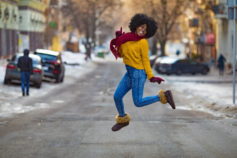 Junge schwarze Frau springt mitten in der Straße lizenzfreie stockfotografie Junge schwarze Frau springt mitten in der Straße lizenzfreie stockfotografie