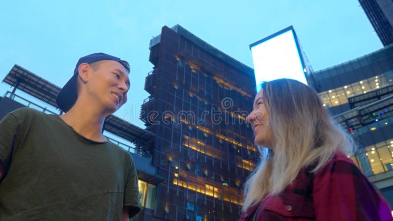 Junge schöne asiatische Paare, Kerl und Mädchen sprechen mit einander und stehen auf der Straße der Stadt stockbilder Junge schöne asiatische Paare, Kerl und Mädchen sprechen mit einander und stehen auf der Straße der Stadt stockbilder