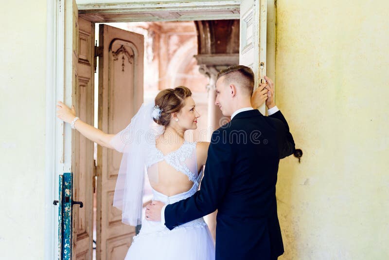 Junge schöne Braut und Bräutigam nahe alter Tür lizenzfreie stockfotos Junge schöne Braut und Bräutigam nahe alter Tür lizenzfreie stockfotos