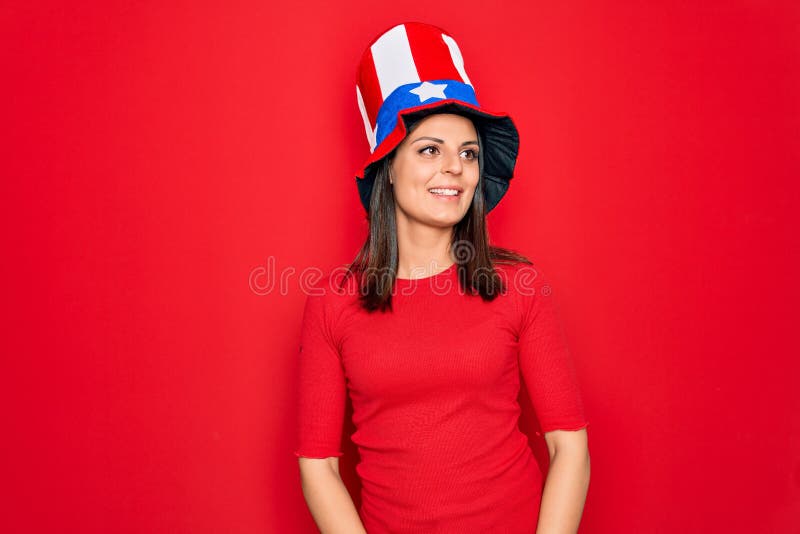 Junge schöne brunette Frau in geeinten Staaten, die den Tag der Unabhängigkeit feiert und mit einem Lächeln im Gesicht zur Seite s stockbilder
