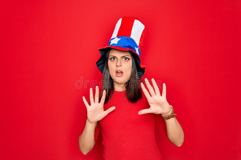 Junge schöne brunette Frau in geeinten Staaten, die den Unabhängigkeitstag feiern Angst und Angst Ausdruck stockfotos