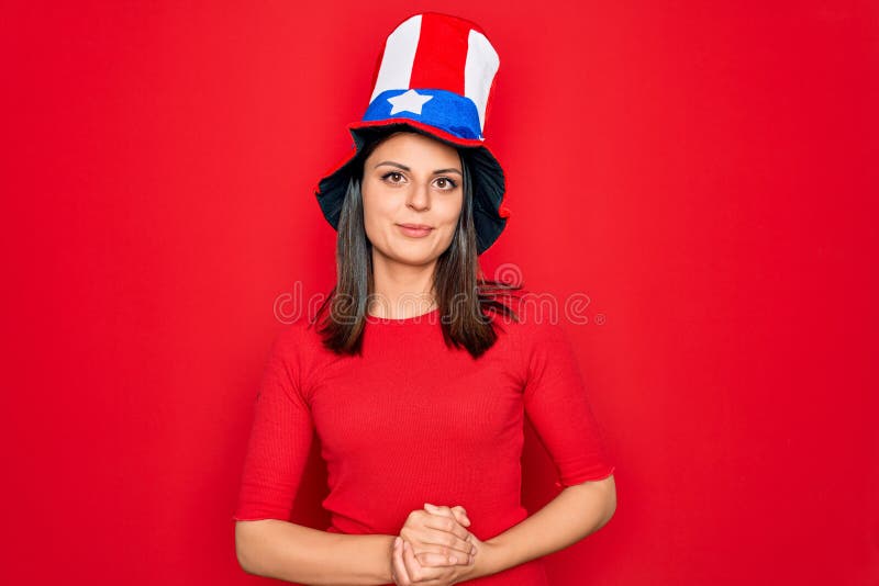 Junge schöne brunette Frau in geeinten Staaten, die feiert Unabhängigkeitstag mit Händen zusammen und die Finger gekreuzt stockfotos