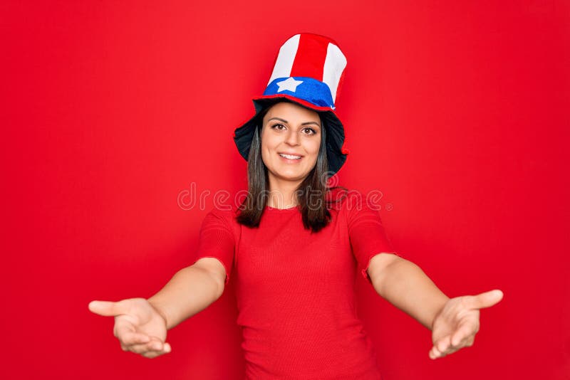 Junge schöne brunette Frau in vereinten Staaten, die feiern Unabhängigkeitstag lächelnd fröhlich, die Hände geben, die geben lizenzfreie stockfotografie