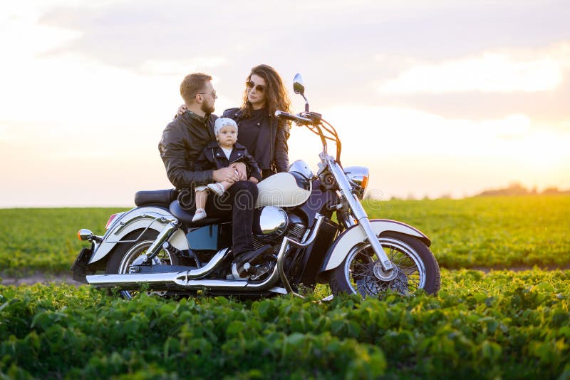 Junge schöne Familie Vater Mutter und kleine Tochter fahren Motorrad stockfotografie