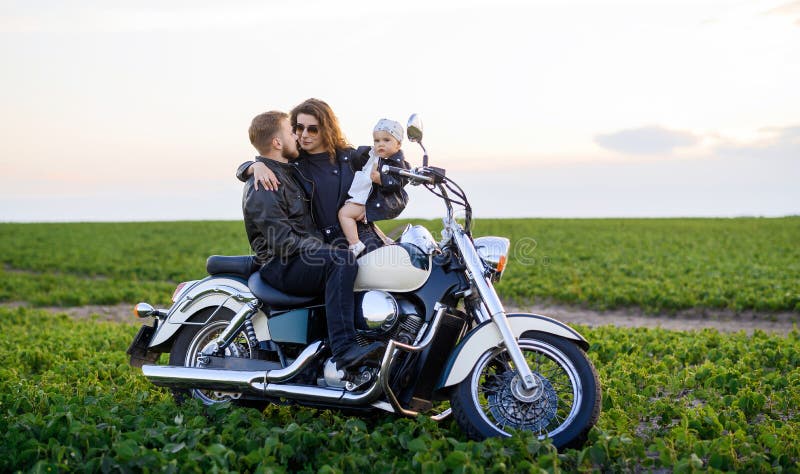 Junge schöne Familie Vater Mutter und kleine Tochter fahren Motorrad lizenzfreie stockfotos