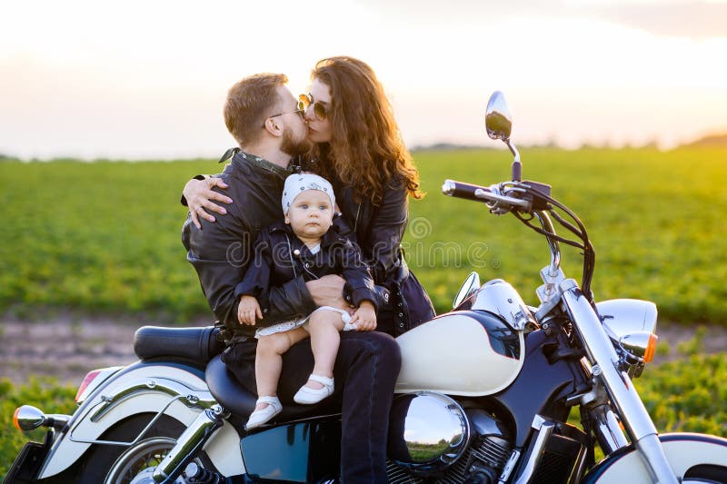 Junge schöne Familie Vater Mutter und kleine Tochter fahren Motorrad lizenzfreie stockfotos