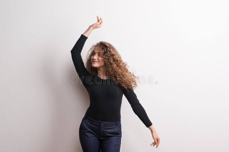 Junge schöne glückliche Frauenstellung im Studio, Tanzen stockbild