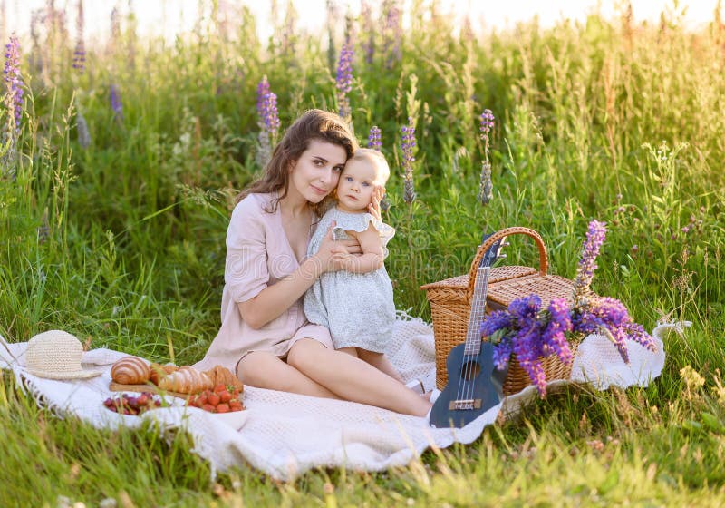 Junge schöne Mutter, die mit ihrer kleinen Tochter picknicken lizenzfreies stockbild