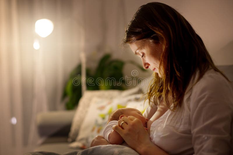 Junge schöne Mutter, ihr neugeborenes Baby an Ni stillend stockfotografie Junge schöne Mutter, ihr neugeborenes Baby an Ni stillend stockfotografie
